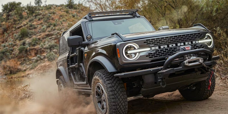black 2024 ford bronco driving through a dirt backroad 